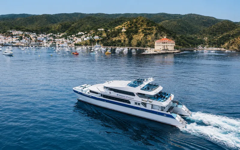 A catamaran ferry approaching Catalina Island, California, with the Avalon Casino building visible on the point