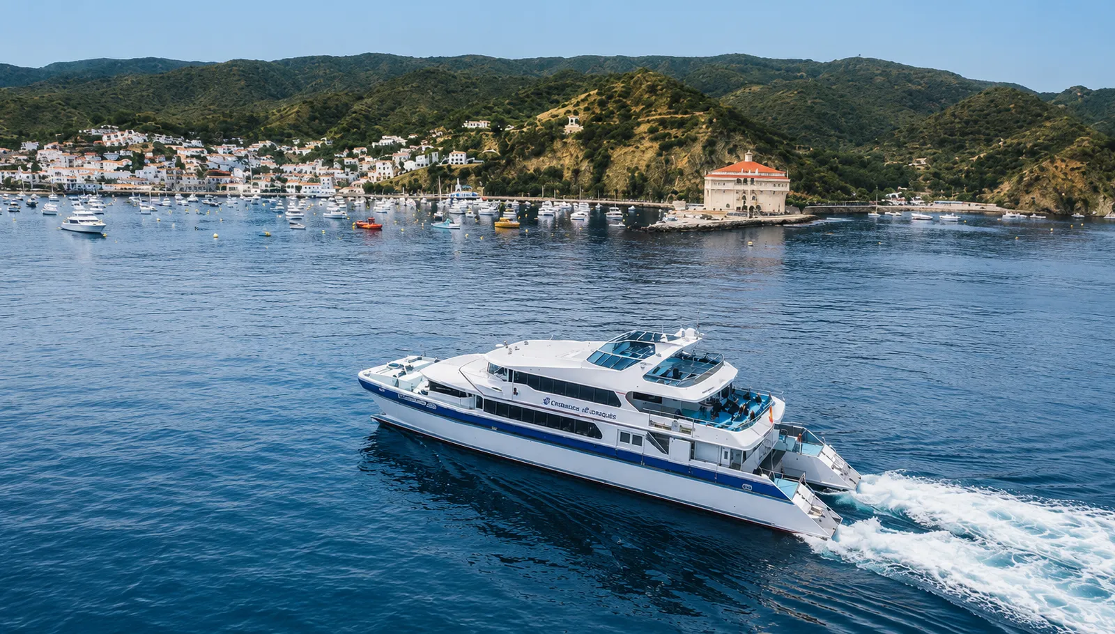 A catamaran ferry approaching Catalina Island, California, with the Avalon Casino building visible on the point